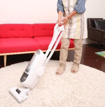 家事で掃除機をかける女性